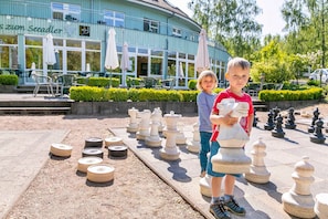 A chessboard set up outdoors with a building in the background.