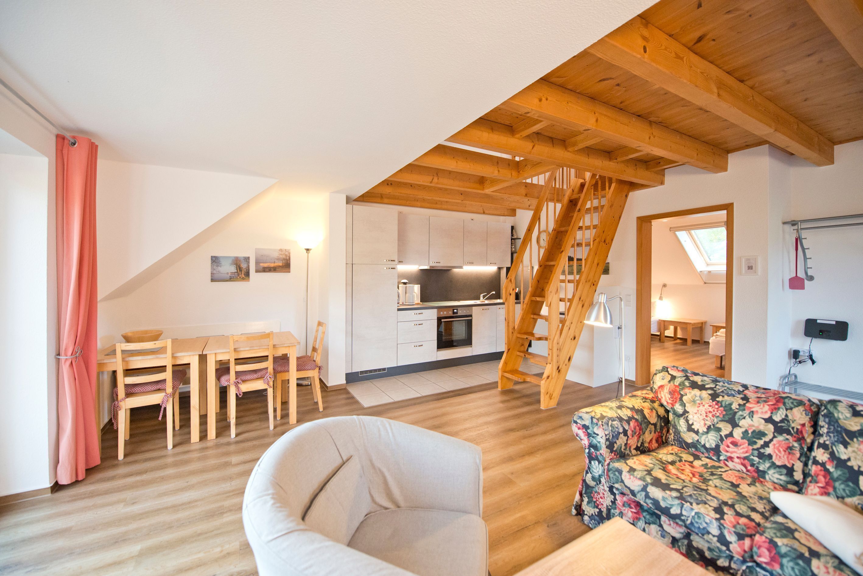 Ein Loft-Wohnraum mit Küche, Essbereich und Treppe.