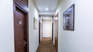 A hallway with wooden doors, numbered 505, and framed artwork on the walls. - Hotel Golden Square Bishkek (Bishkek)