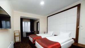 A hotel room with two beds, a TV mounted on the wall, a desk, and a chair. - Hotel Golden Square Bishkek (Bishkek)
