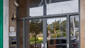 A building entrance with a glass door and a number '20' above it. - Parthenon 2BD Apartment (Athens)