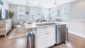 Een moderne keuken met een centraal kookeiland, roestvrijstalen apparatuur en een eethoek met uitzicht op de omgeving.