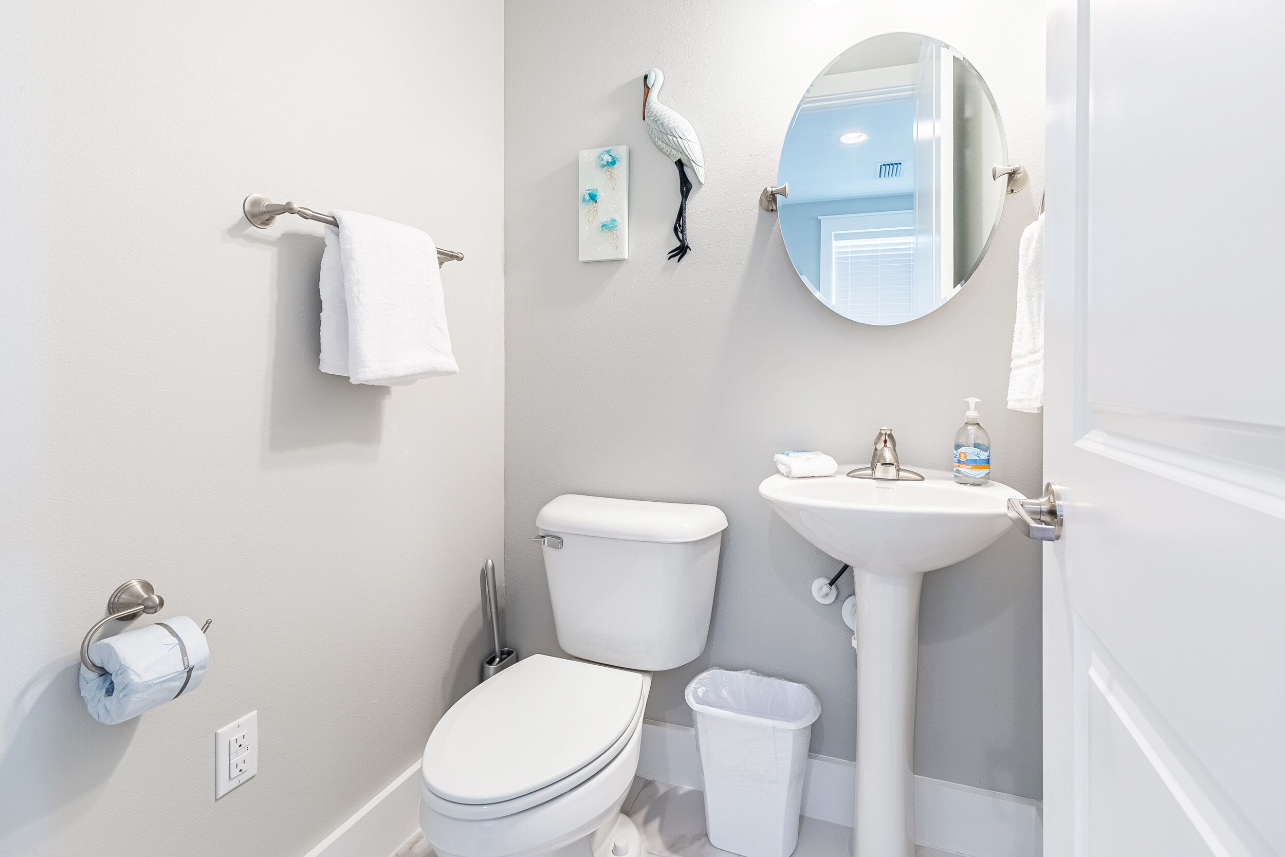 A bathroom with a toilet, sink, and mirror.