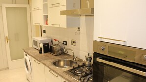 Una cocina moderna con electrodomésticos de acero inoxidable, horno empotrado y un lavamanos.