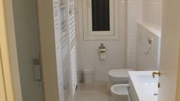 Une petite salle de bain comprenant des toilettes, un lavabo et une douche.