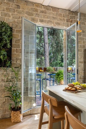 A kitchen with a stone wall, a large window, and a view of trees.