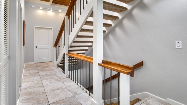 A staircase with wooden handrails and a white door at the top. - Kanaloa at Kona 1606: Beautiful Oceanview Condo w/ Shared Pool, Spa, AC & Lanai (Kailua Kona)