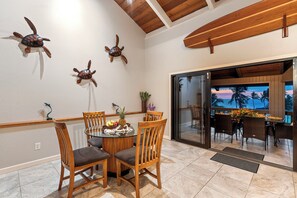 A dining area with a round table, wooden chairs, and decorative turtle wall art.
