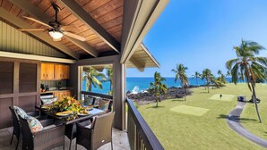 A covered outdoor dining area with a view of the ocean and a golf course. - Kanaloa at Kona 1606: Beautiful Oceanview Condo w/ Shared Pool, Spa, AC & Lanai (Kailua Kona)