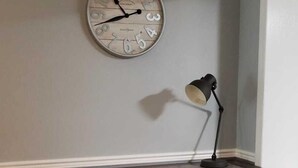 A corner desk with drawers, a wall clock, and a lamp. - The Flo's house, Snowbird Winter Haven • Spacious 1800 sq ft Home with New Lanai (Tampa)