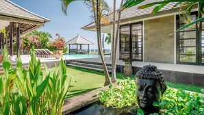 A resort with a swimming pool, a gazebo, and a Buddha statue.