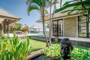 Ett semesterhotell med en swimmingpool, en lusthus och en Buddha-staty.