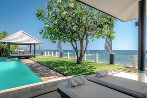 A poolside area with a lounge chair, a small gazebo, and a view of the sea. - Beachfront pool villa: Free welcome dinner! With own boat! (Dencarik)