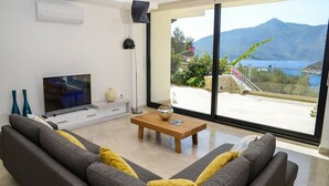 A modern living room with a sofa, a coffee table, and a television.