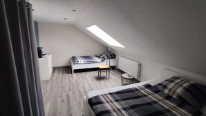 Una stanza piccola e funzionale con letto a soppalco, scrivania e sedia.
