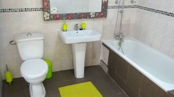 A bathroom with a toilet, sink, and bathtub.