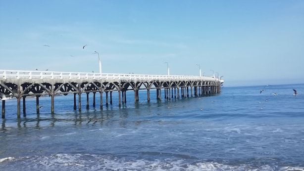 A pier extending into the water with a clear sky above. - Casa Blue Hill Beach (Cerro Azul)