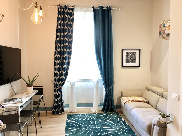 A compact living space with a bed, a desk, and a TV.