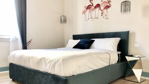 Ein modernes Schlafzimmer mit einem großen Bett, einem dunklen Kopfteil und einer Wandleuchte.