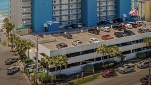 Um hotel alto com fachada azul, várias varandas e uma garagem.