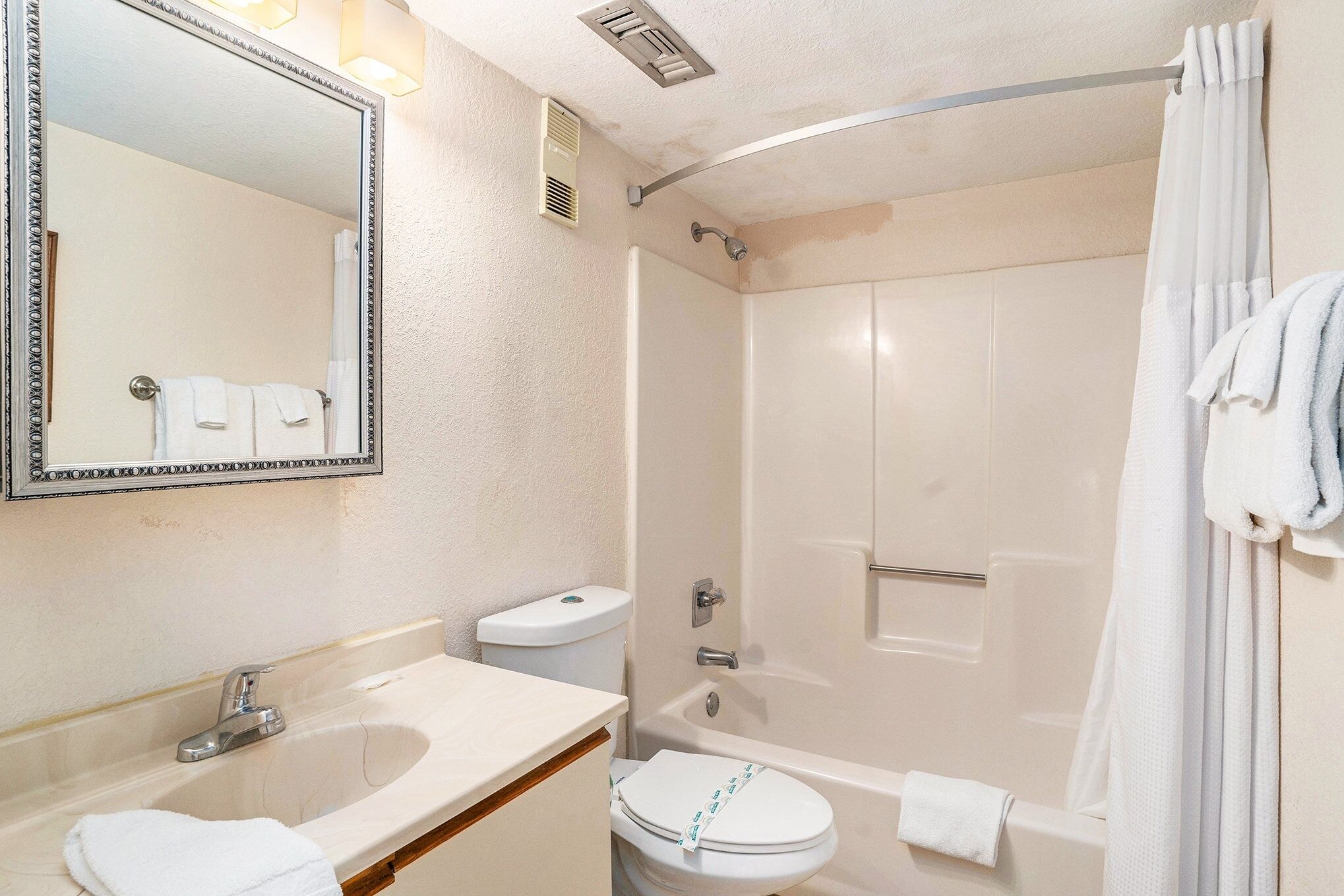 A bathroom with a sink, toilet, and shower.