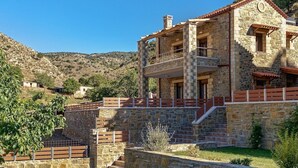 A stone building with a balcony, surrounded by a stone wall and steps leading up to it. - Villa Nikos - Faraggi Villas (Zoniana)