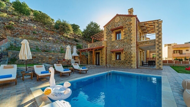 A stone villa with a swimming pool, lounge chairs, and umbrellas. - Villa Nikos - Faraggi Villas (Zoniana)