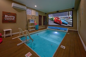 An indoor pool with a no diving sign, a pool rules sign, and a 'Merry Christmas' decoration.