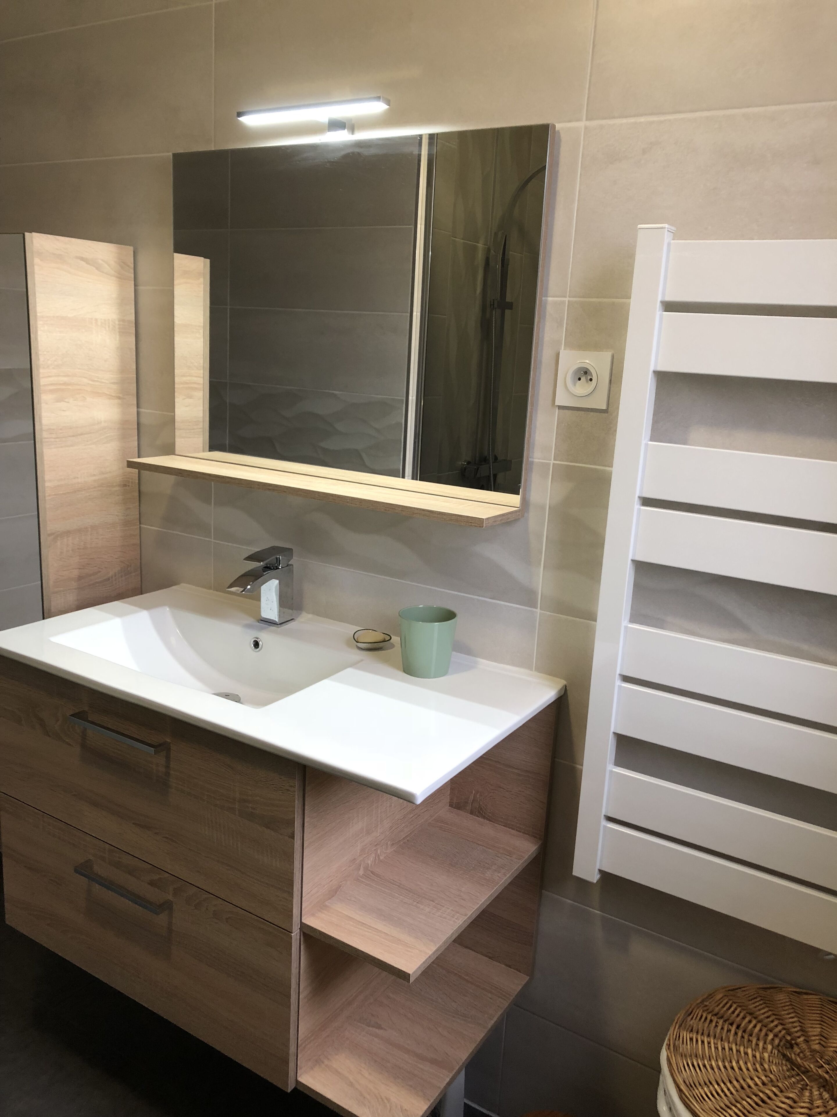 A bathroom with a white sink, a mirror, and a towel rack.