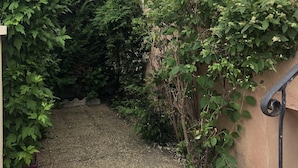 A building with a beige exterior, a window with a white frame, and a small balcony with a metal railing. - Large terraced house, with garden, in quiet area (Dijon)