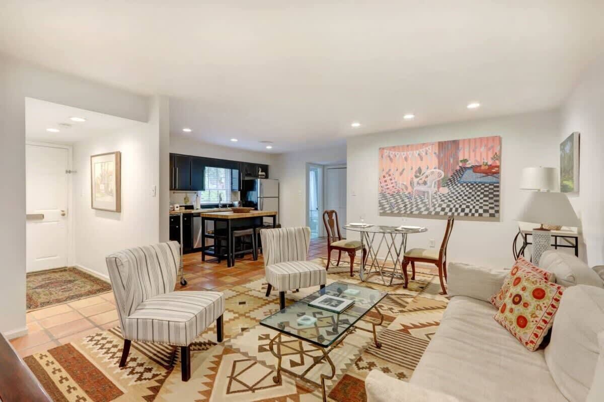 A living room with a sofa, armchairs, a coffee table, and a dining area with a table and chairs.
