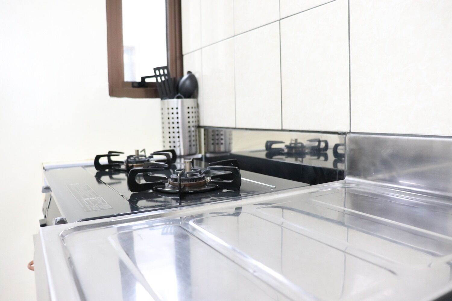 Een koelkast, een magnetron, een kookplaat, kookgerei, borden en bestek