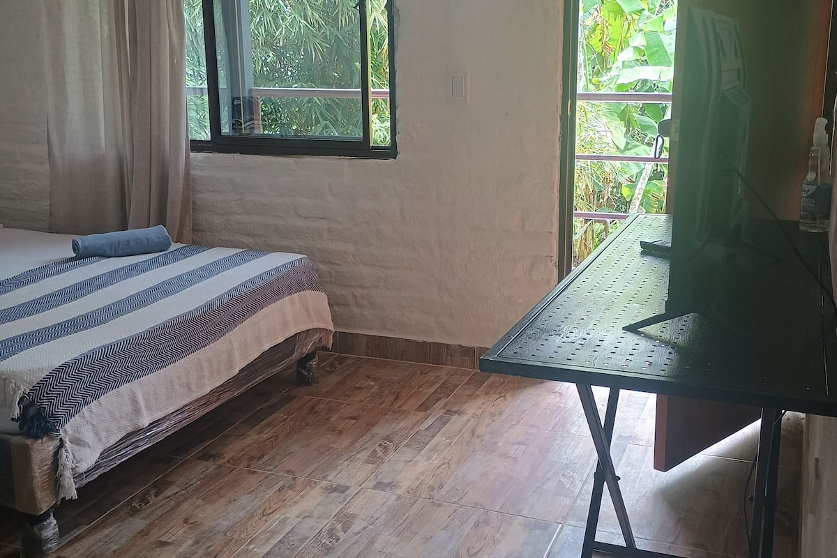 A room with a bed, a desk, and a window.