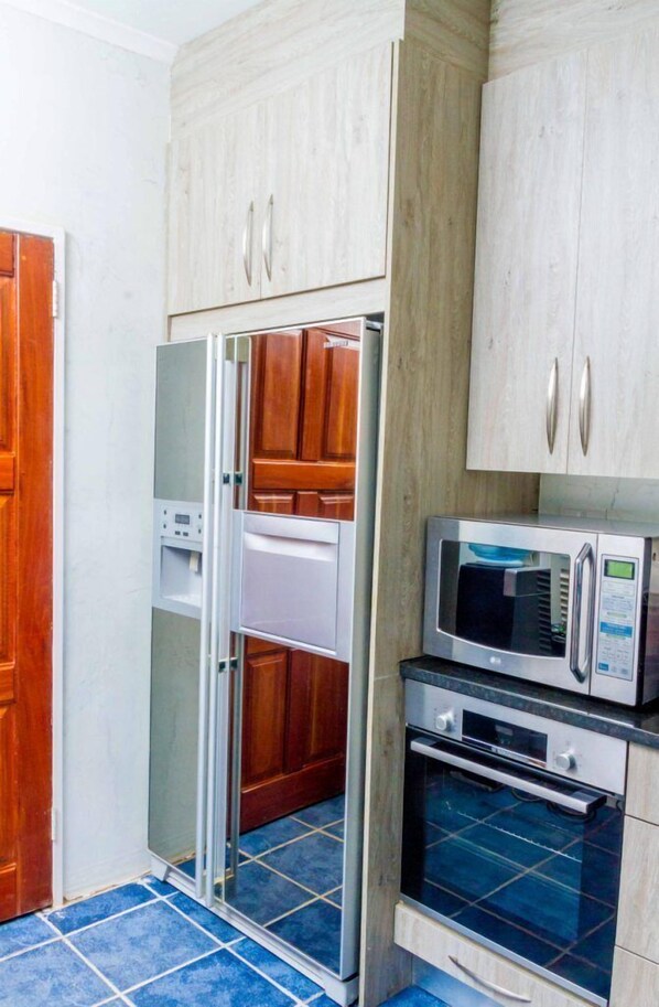 Cocina compacta con refrigerador, microondas y horno.