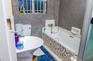 Une salle de bain avec des toilettes, un lavabo et une baignoire.
