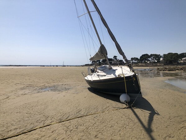 A sailboat anchored on a sandy beach with a clear sky. - MOUETTES 3 - Apartment with sea view between Carnac and Trinité-sur-Mer - T356 (La Trinité-sur-Mer)