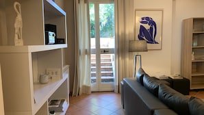 Una sala de estar con un sofá, una lámpara, una estatua y una estantería.