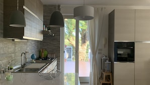 Una cocina moderna con una isla grande, electrodomésticos de acero inoxidable y vistas al exterior.