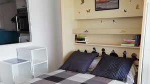 Makuuhuoneessa on sänky, yöpöytä, kirjahylly ja seinälle ripustettu taulu.