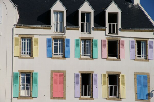 A row of colorful shutters on a building's facade.