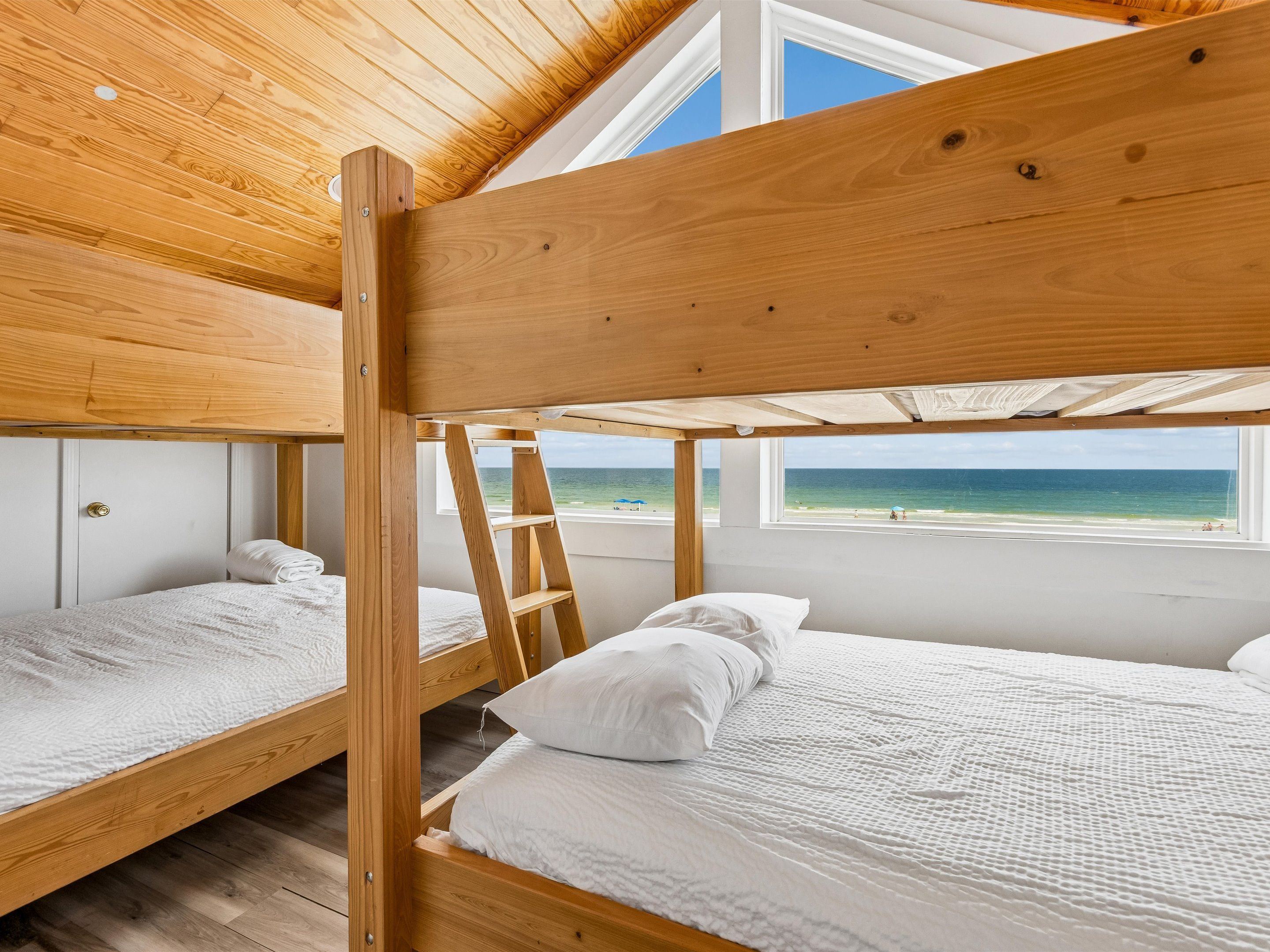 A bunk bed room with a view of the beach.