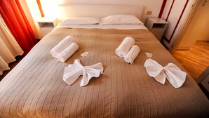 A hotel room with a bed, pillows, and neatly folded towels arranged on the bed. - Park Apartment (Milan)