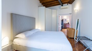 Un dormitorio con una cama grande, un armario, un espejo y un techo de madera.
