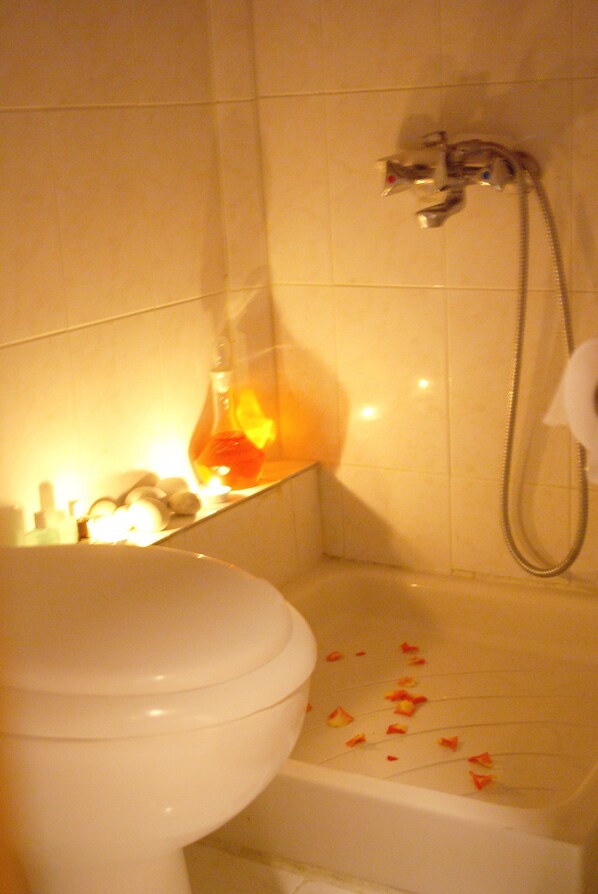A bathroom with a toilet, a shower, and a sink.