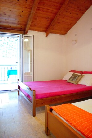 Una habitación con una cama de madera, una ventana y un balcón.