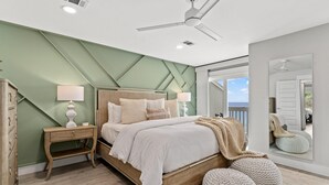 A bedroom with a bed, bedside tables, a ceiling fan, and a large window. - Stunning Gulf Front Townhouse! Private beach, beach chairs, wagon, and cooler! (Santa Rosa Beach)