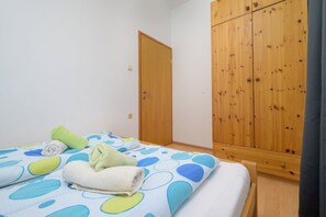 Ein Schlafzimmer mit einem Bett, einem Holzschrank und einer Tür.