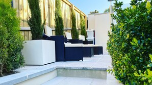 A patio area with outdoor furniture, steps leading up to a wooden deck, and lush greenery. - No3 Highpoint luxury townhouse, 2en-suite bedrooms onsite indoor swimming pool  (Saundersfoot)