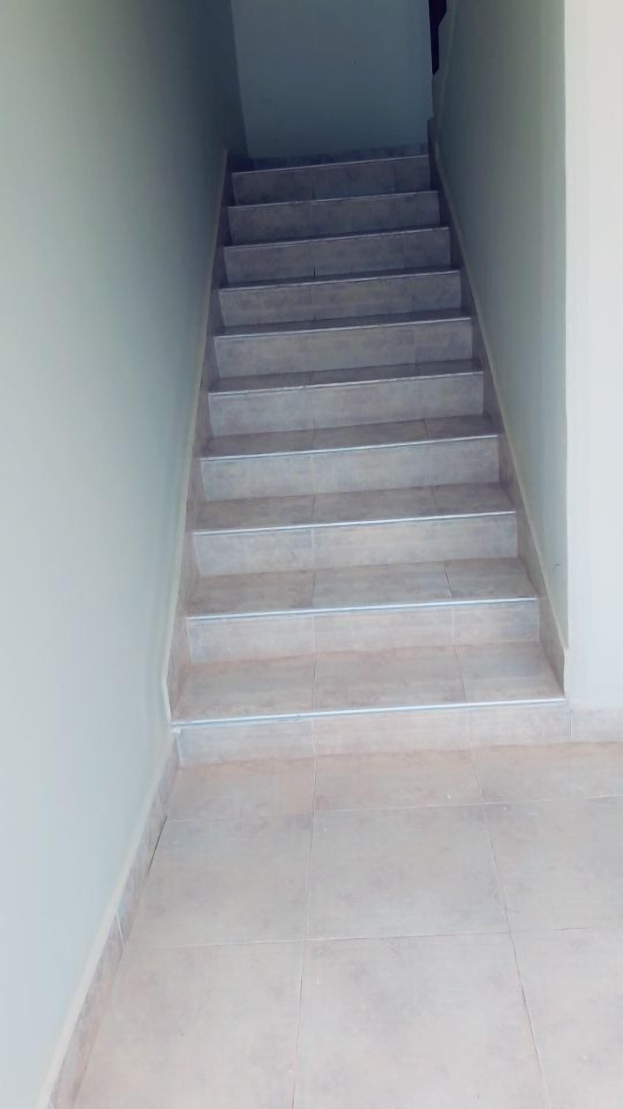 A staircase with a tiled floor leading upwards.