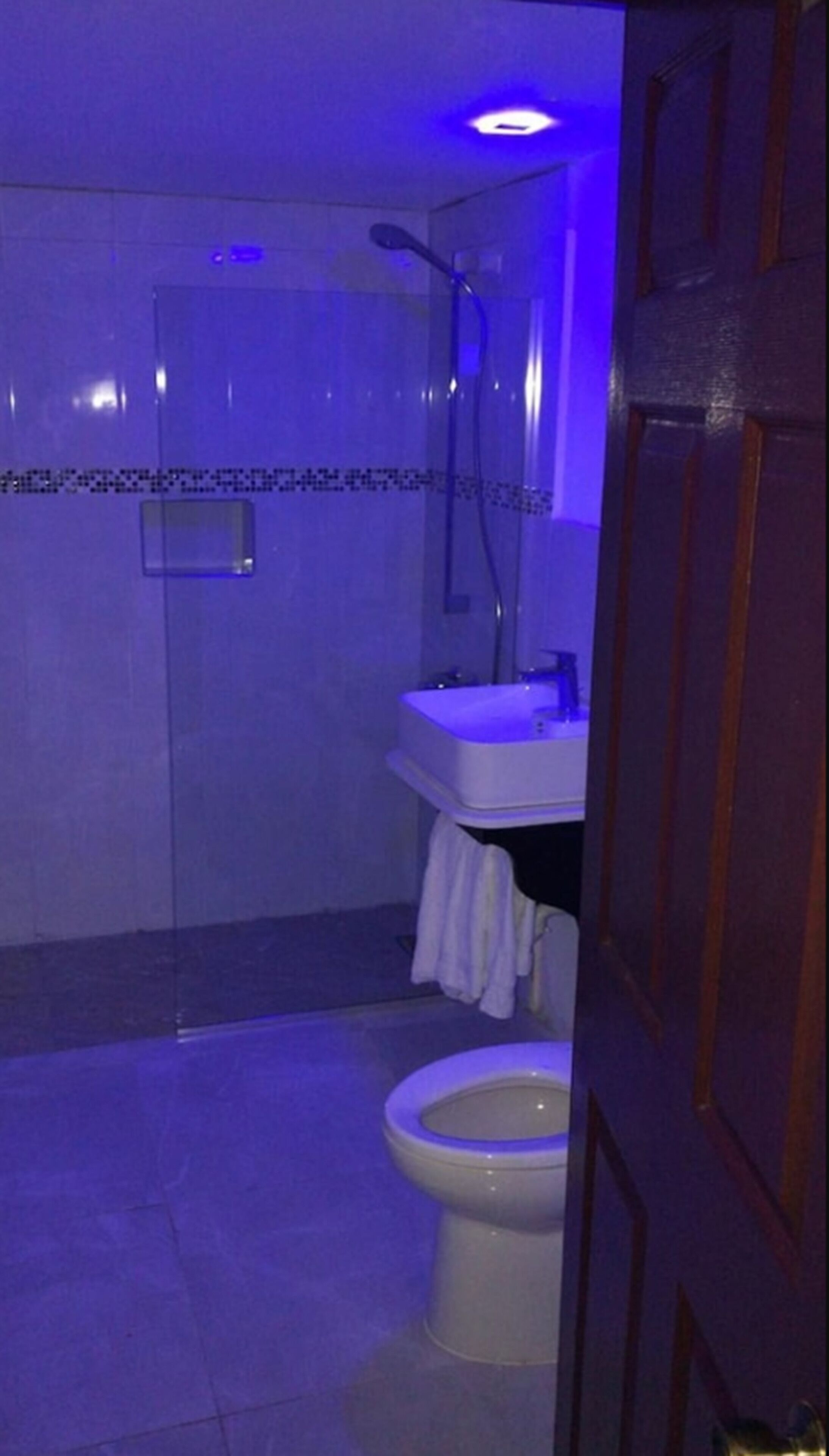 A bathroom with a shower, sink, and toilet.